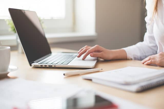 partial image of a person's hand with a laptop